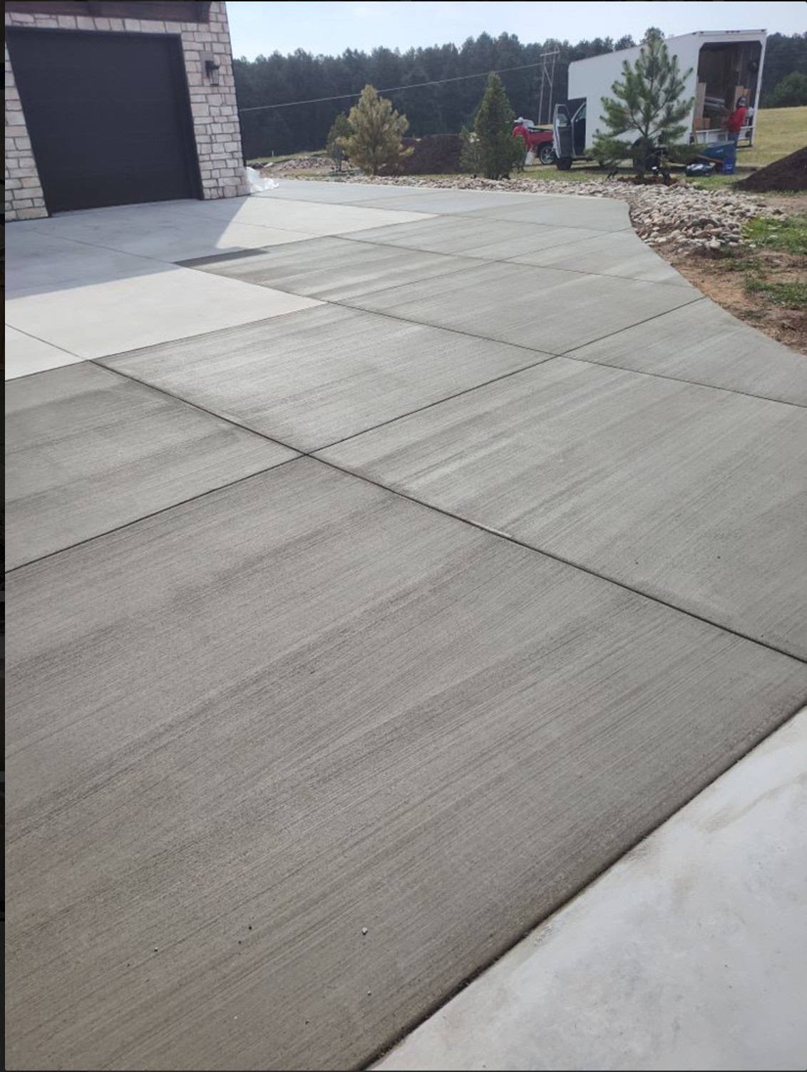 Large broom‑finish concrete driveway panels with saw‑cut joints at a rural Colorado Springs property