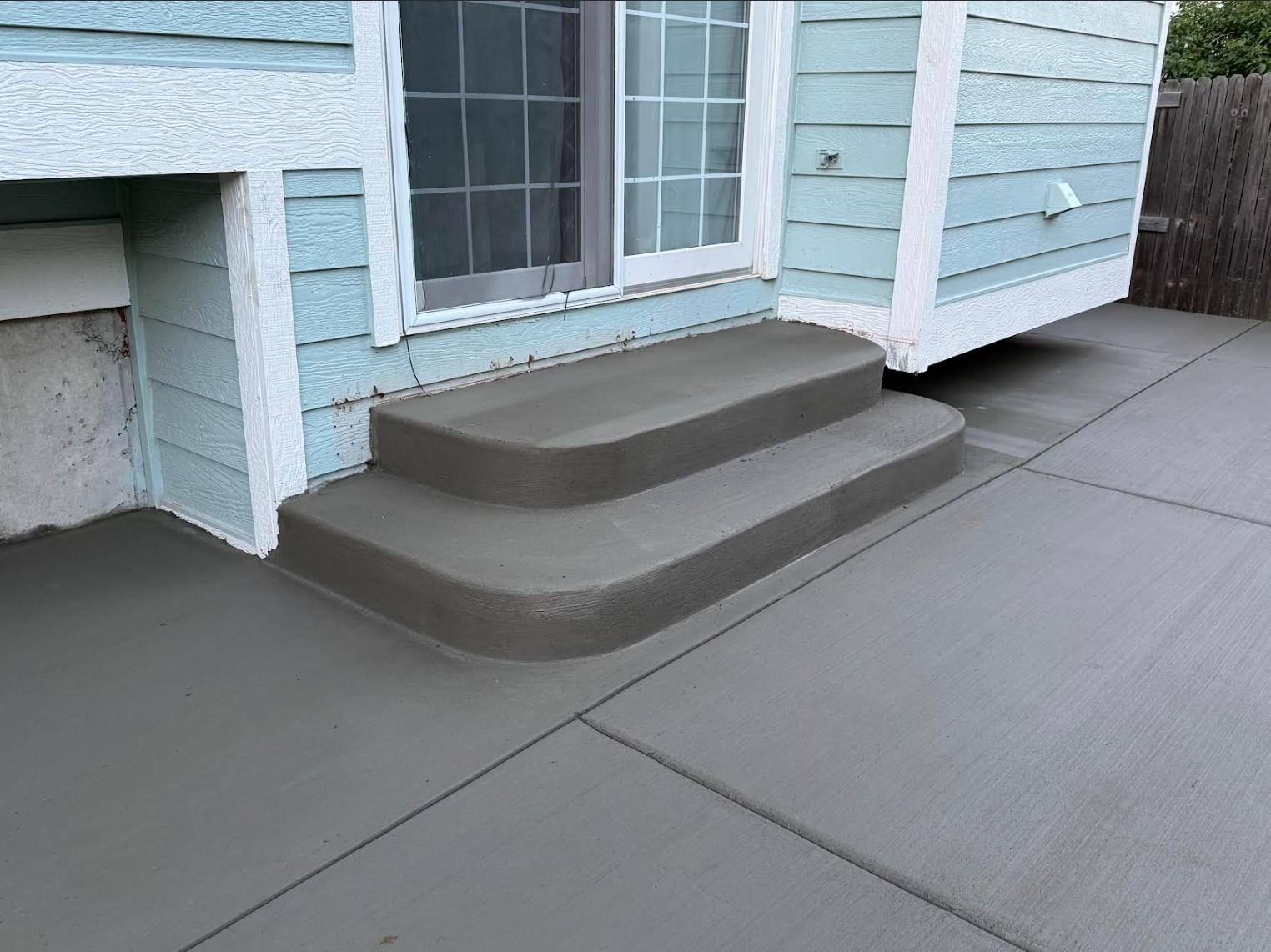 Close-up of rounded concrete steps leading to backyard patio with crisp trowel lines, Colorado Springs
