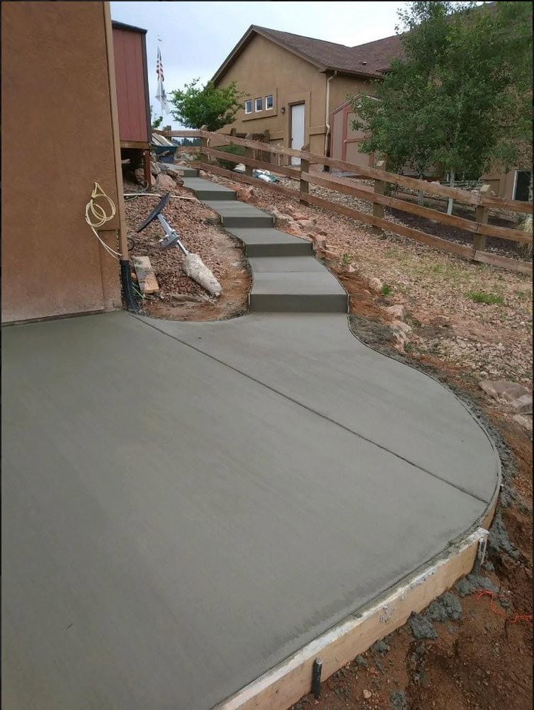 Stepped concrete path climbing a hillside, connecting patio to upper yard in Colorado Springs